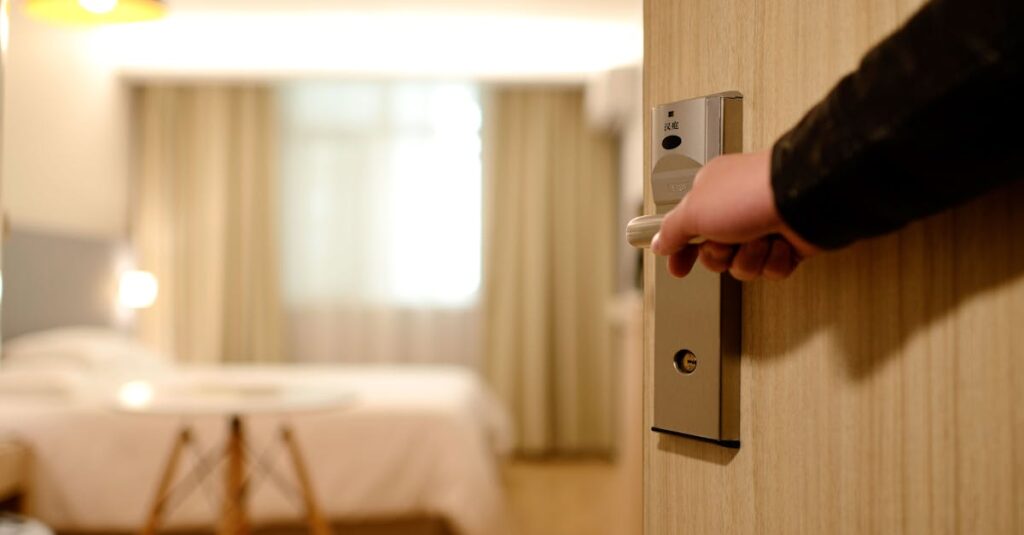 Person Holding on Door Lever Inside Room