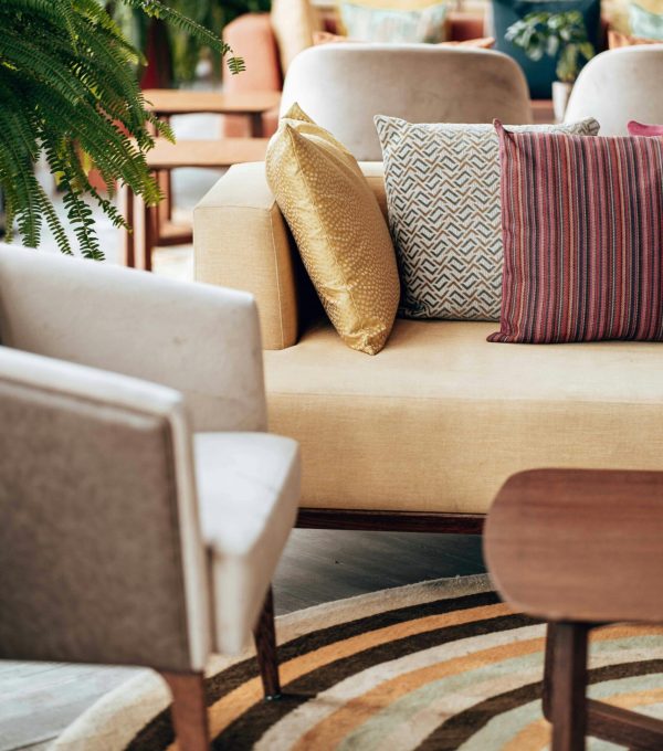 A modern living room with stylish throw pillows and a circular rug.